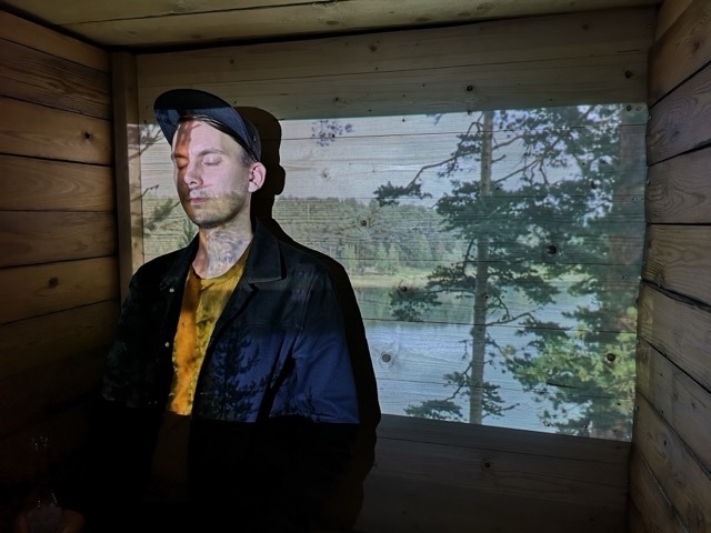 Portrait of Kasperi Mäki-Reinikka in front of a projected image