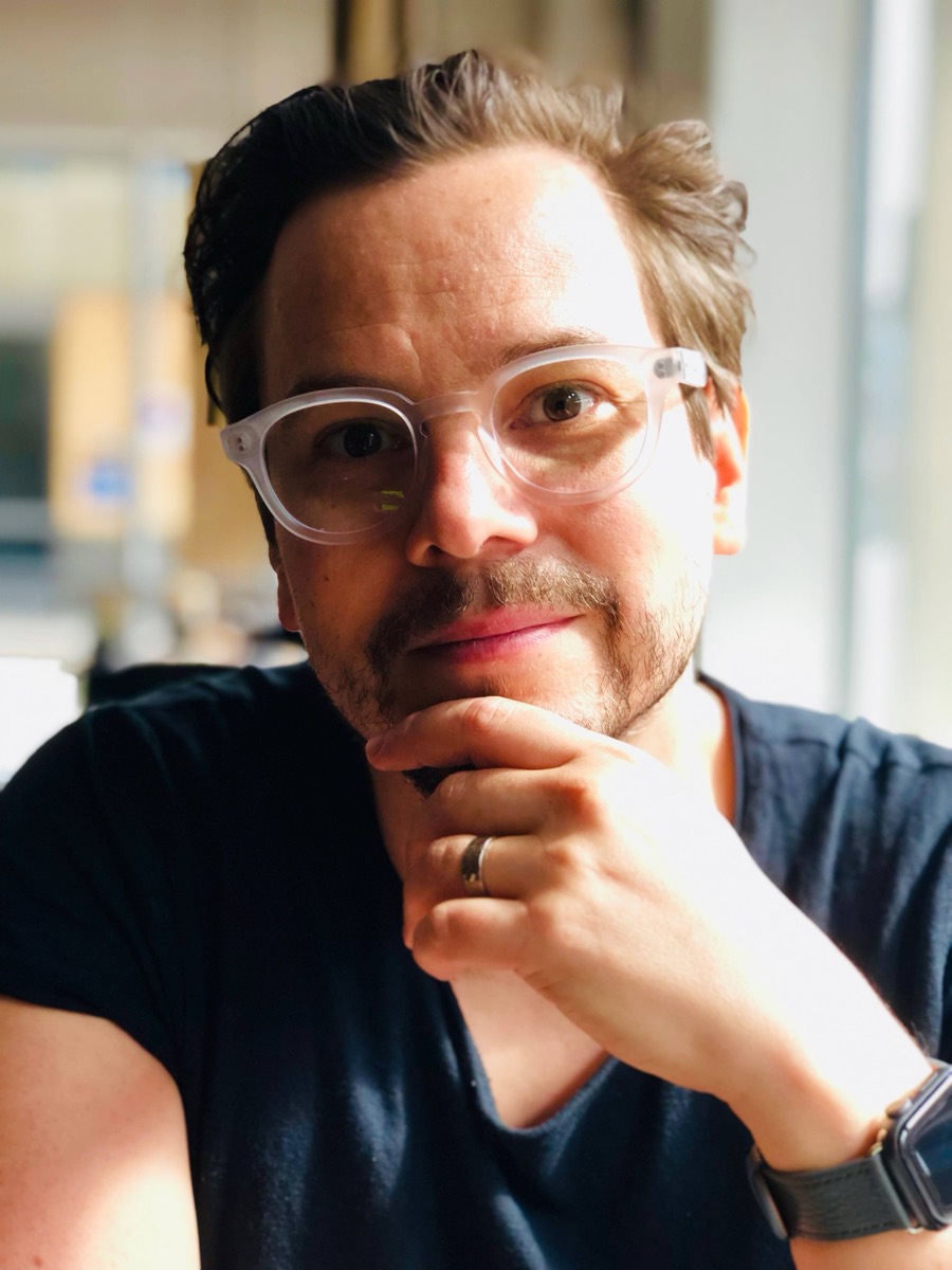 Portrait of Tomi Slotte Dufva wearing translucent glasses
